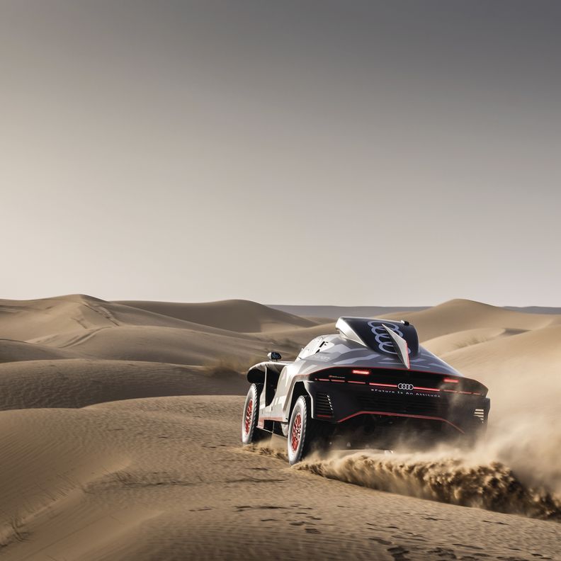 The Audi RS Q e-tron crosses a desert landscape.