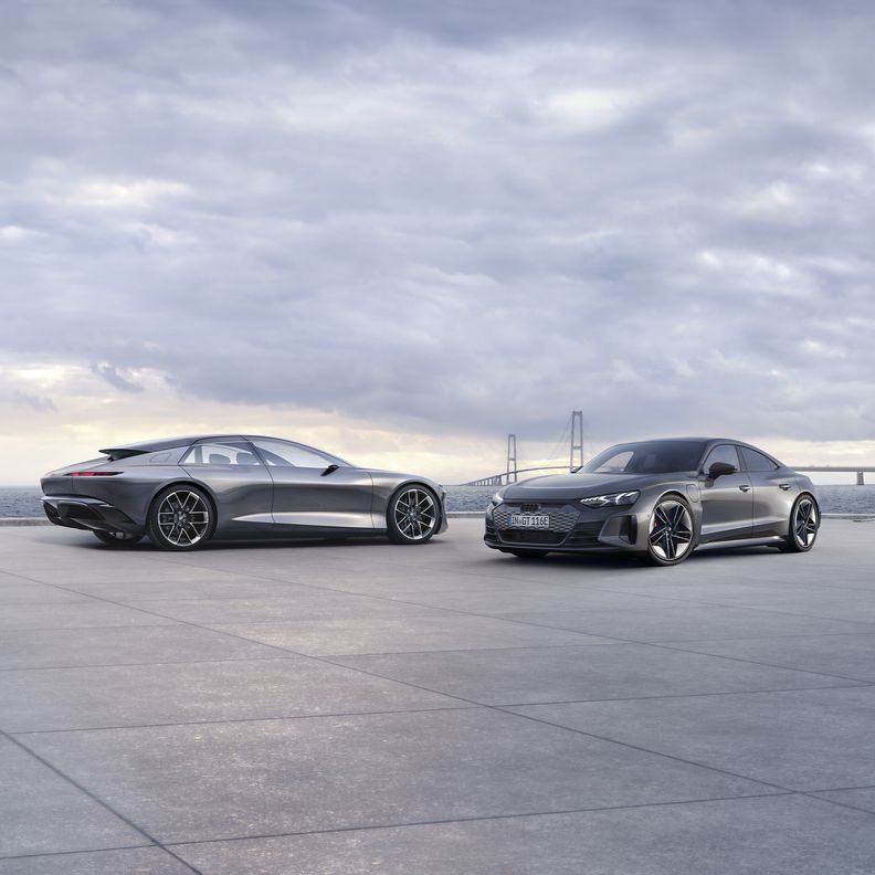 The Audi grandsphere concept and the Audi RS e-tron GT in an open area against a cloudy sky.