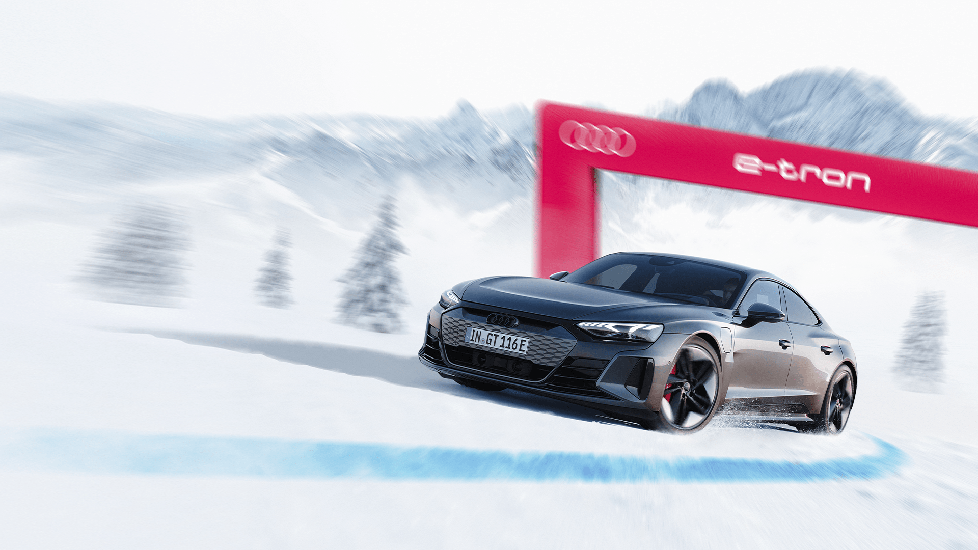 Ein schwarzer Audi RS e-tron GT fährt auf einer verschneiten Straße mit den Alpen im Hintergrund.