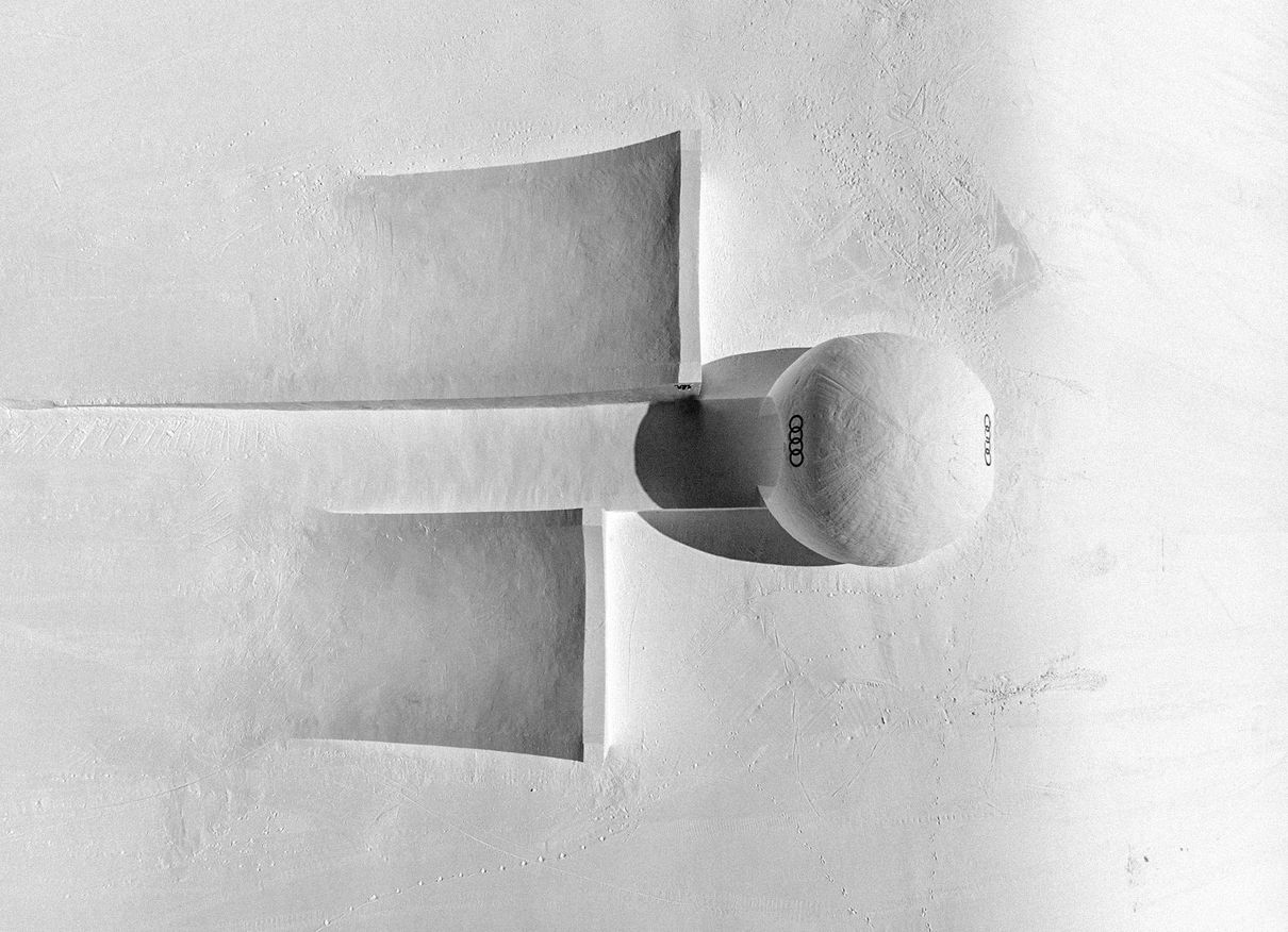 Eine riesige Kugel aus Eis und Schnee ist hinter zwei Sprungschanzen, Kicker genannt, platziert.