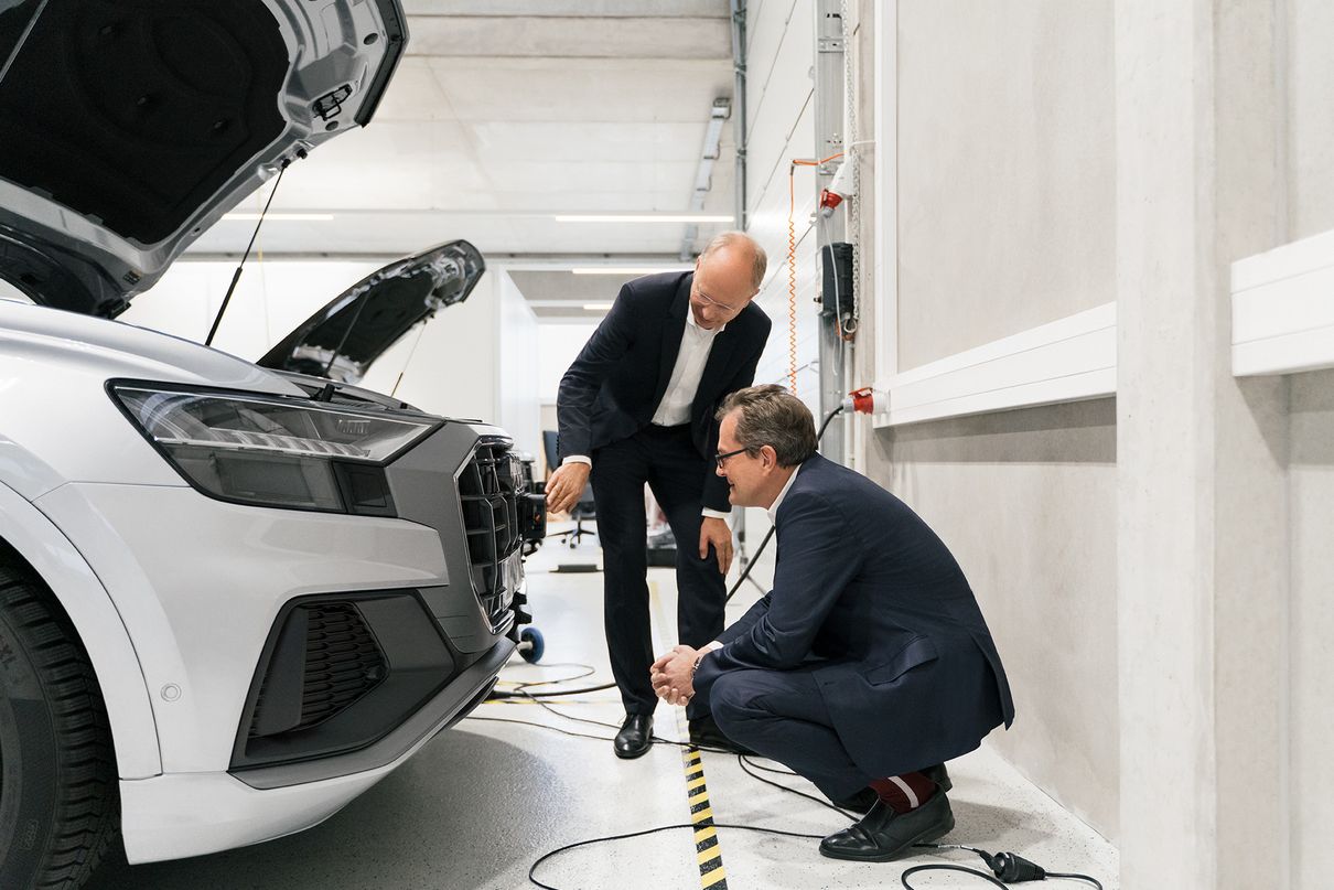 Prof. Christoph Lütge, Dr. Thomas Dahlem ve Dr. Essayed Bouzouraa, bir Audi modelinin ön tarafındaki sensör teknolojisi hakkında konuşuyor.
