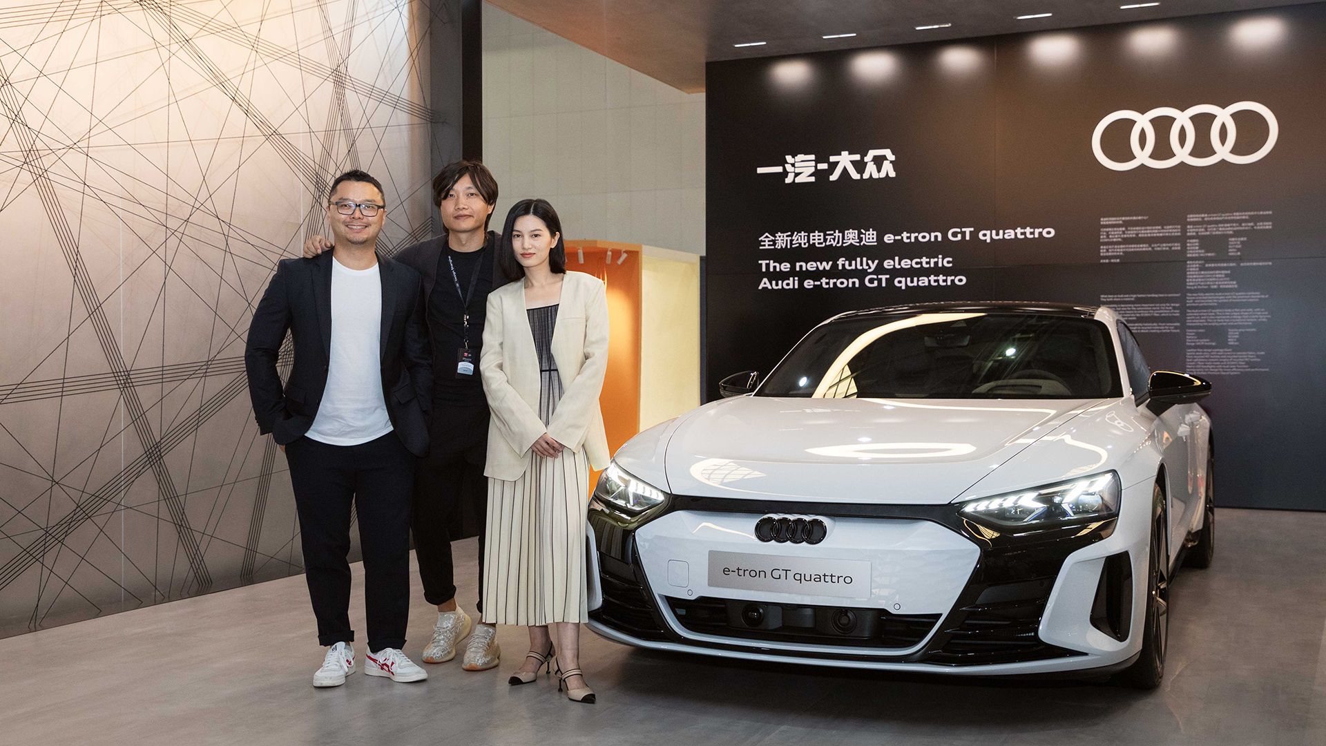 Yu (Scott) Zhao, Directeur de la recherche sur l'innovation chez Audi China, et Yunzhou Wu, Concepteur principal et coordinateur du design intérieur avec l'influenceuse Licheng Ling devant l'Audi e-tron GT quattro