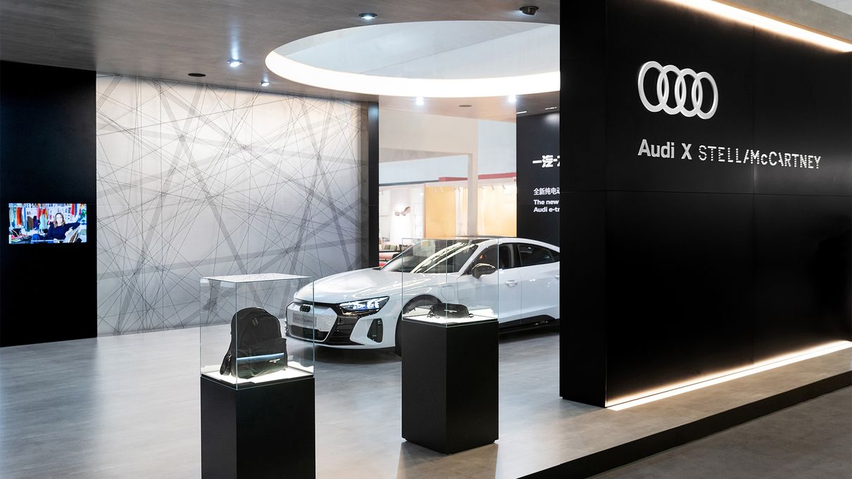 The Audi booth with the Audi e-tron GT quattro and two bags from Stella McCartney's Falabella Go collection.