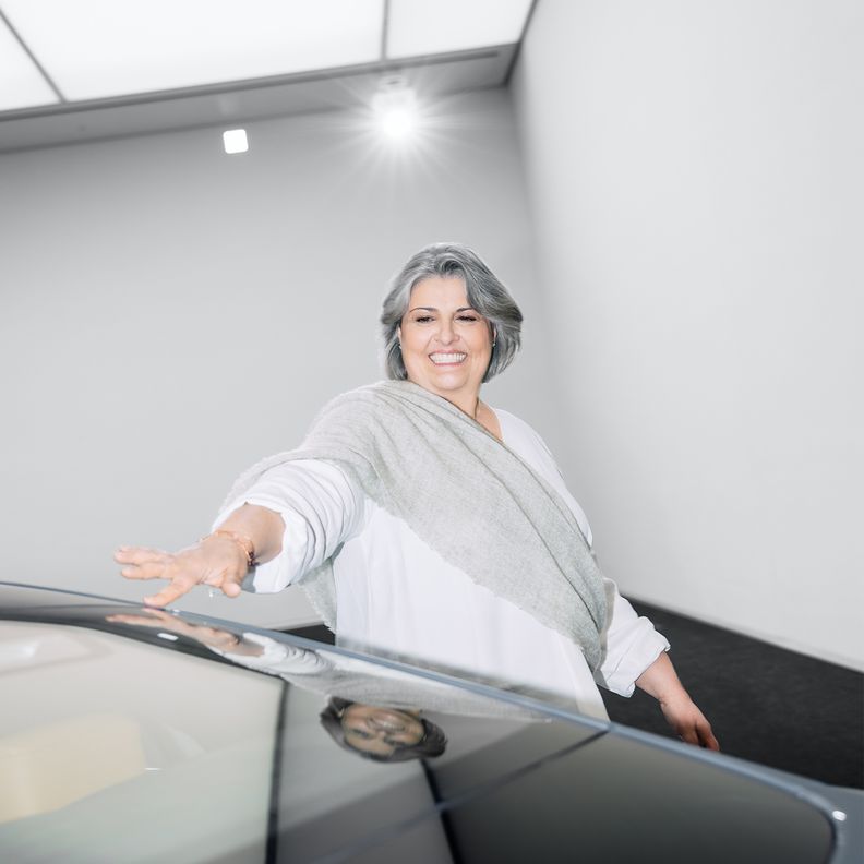 Simona Falcinella, hoofd van de afdeling Color & Trim bij Audi, raakt met een glimlach het oppervlak van een auto aan. 