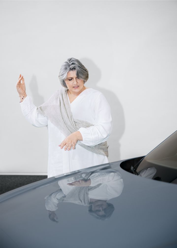Simona Falcinella stands in front of a vehicle and gestures. 