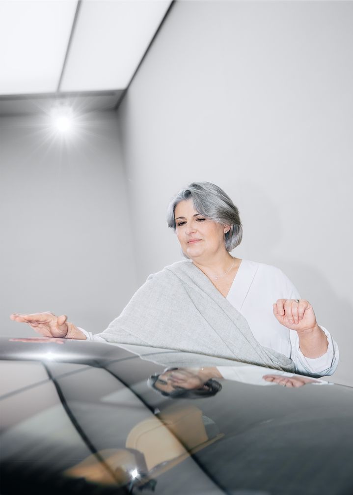 Simona Falcinella betrachtet Lichtspiegelungen auf einer Fahrzeugoberfläche. 