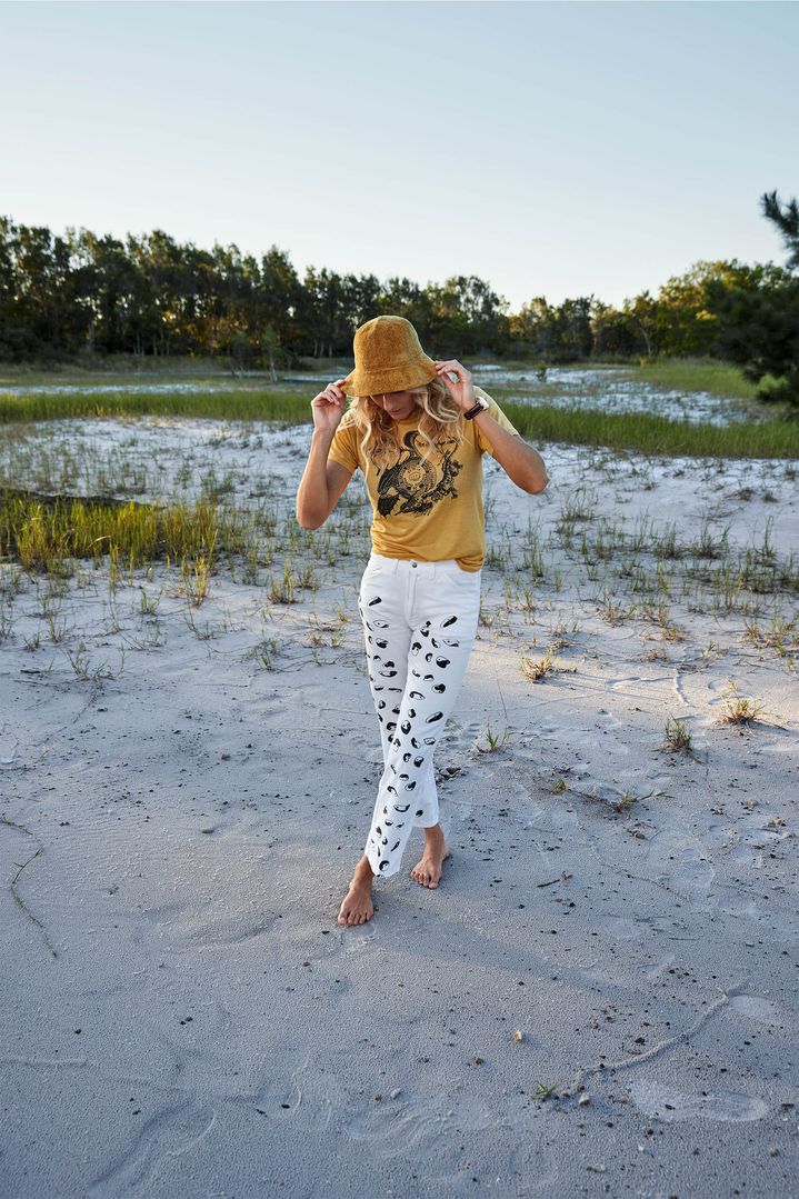 Steph Gilmore outside, in long shot, wearing a sun hat