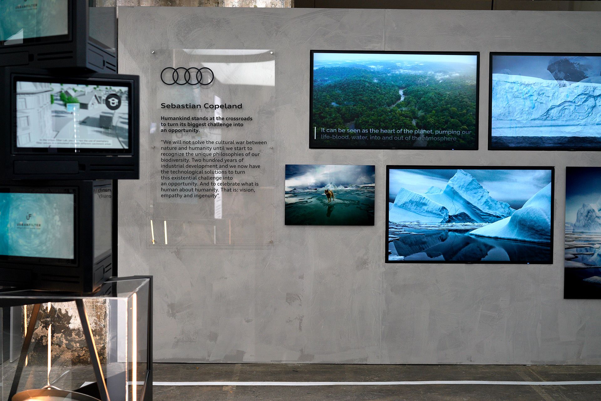 Diverse Bilder des Fotografen hängen an einer Wand des Audi Stands.