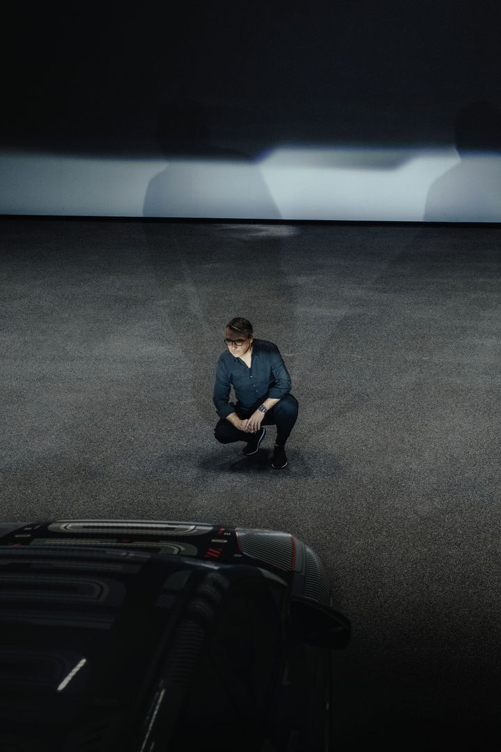 César Muntada blickt hockend in die Scheinwerfer des Audi Q4 e-tron.