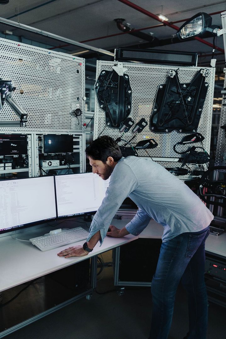 Thomas Gensberger, responsabile dei progetti delle funzioni standard di illuminazione esterna di Audi, davanti a uno schermo in un laboratorio di prova Audi.