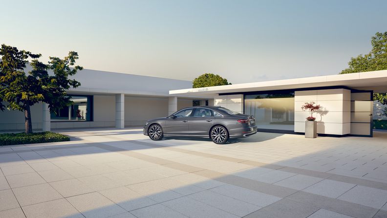 Bir evin garaj yolunun önünde duran Audi A8. 