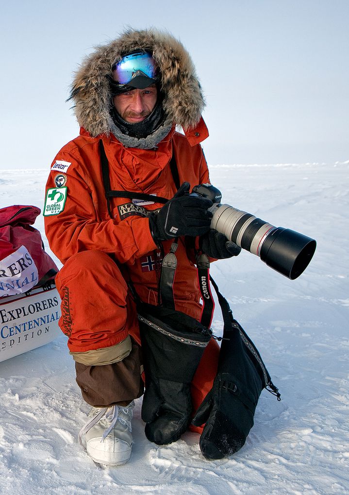 Sebastian Copeland op expeditie in de sneeuw met een camera in zijn hand. 