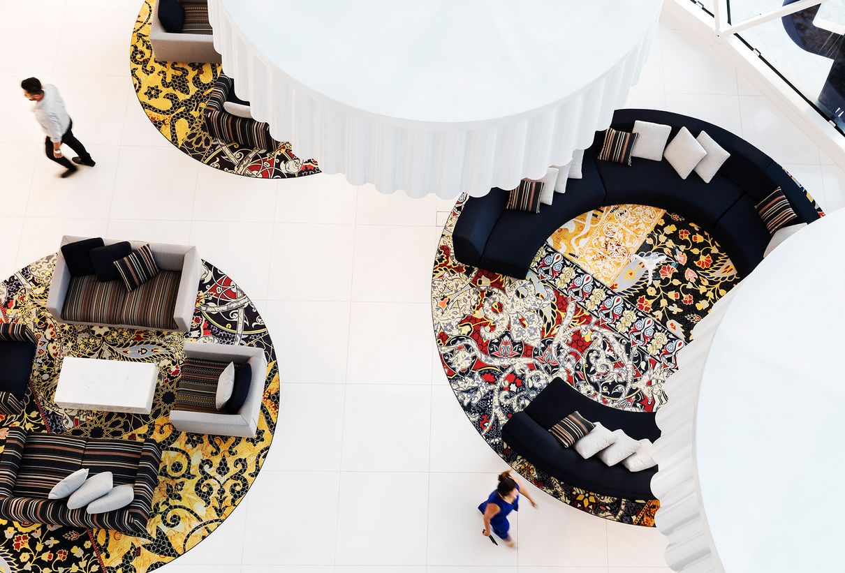 Eine Hotellobby aus der Vogelperspektive mit runden, bunten Sitzinseln.