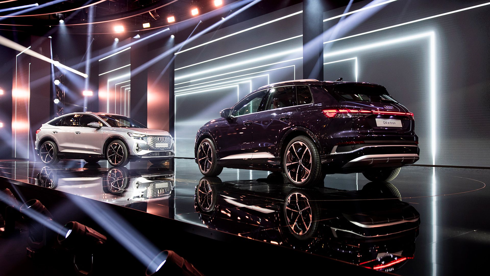 Due modelli Audi Q4 e-tron l’uno di fronte all’altro sul palcoscenico.