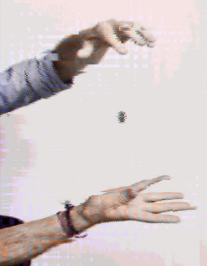 primer plano de las manos de Tristan haciendo un truco de magia con una moneda, ambos con filtro "parpadeo de pantalla"
