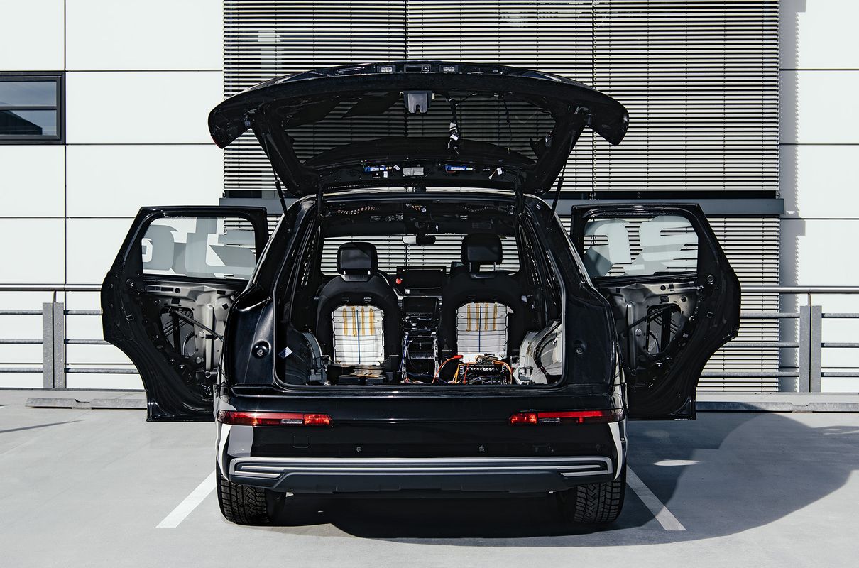 Heckansicht des Konzeptfahrzeugs Brutus mit geöffneter Heckklappe und  geöffneten Seitentüren, die den Blick auf Elektronik im Kofferraum und entfernte Innenverkleidungen freigeben.  