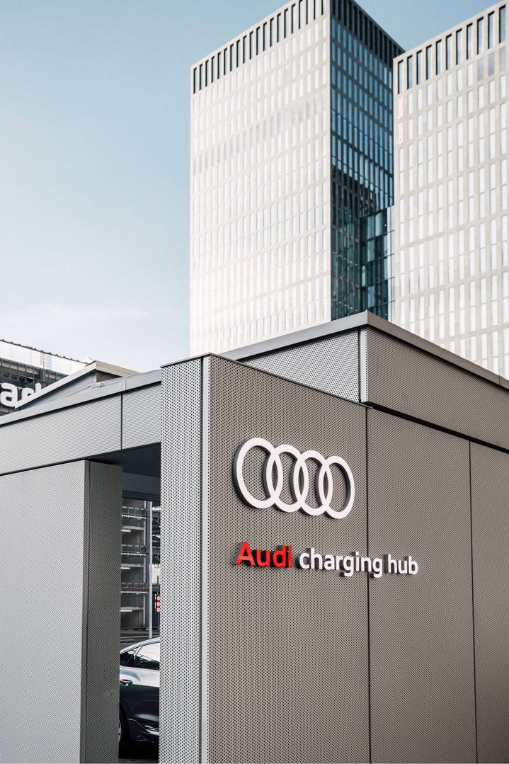 Audi charging hub, im Hintergrund Hochhäuser.