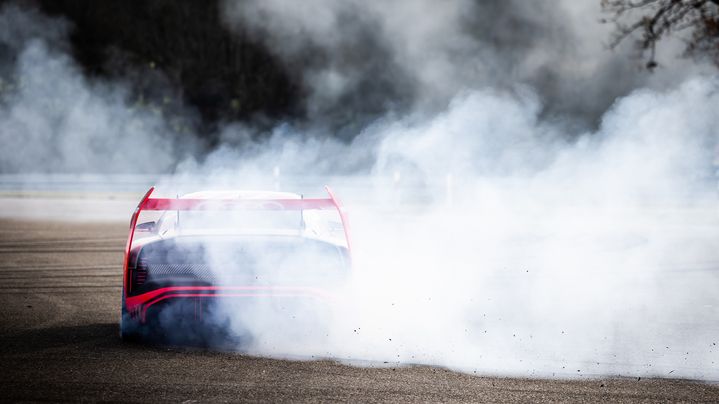 The spinning tyres of the Audi S1 Hoonitron cover the rear in fog.