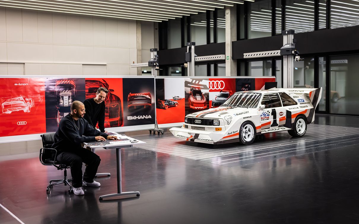 Sascha Heyde in conversation with Marco dos Santos. In the background is the Audi Sport quattro S1.