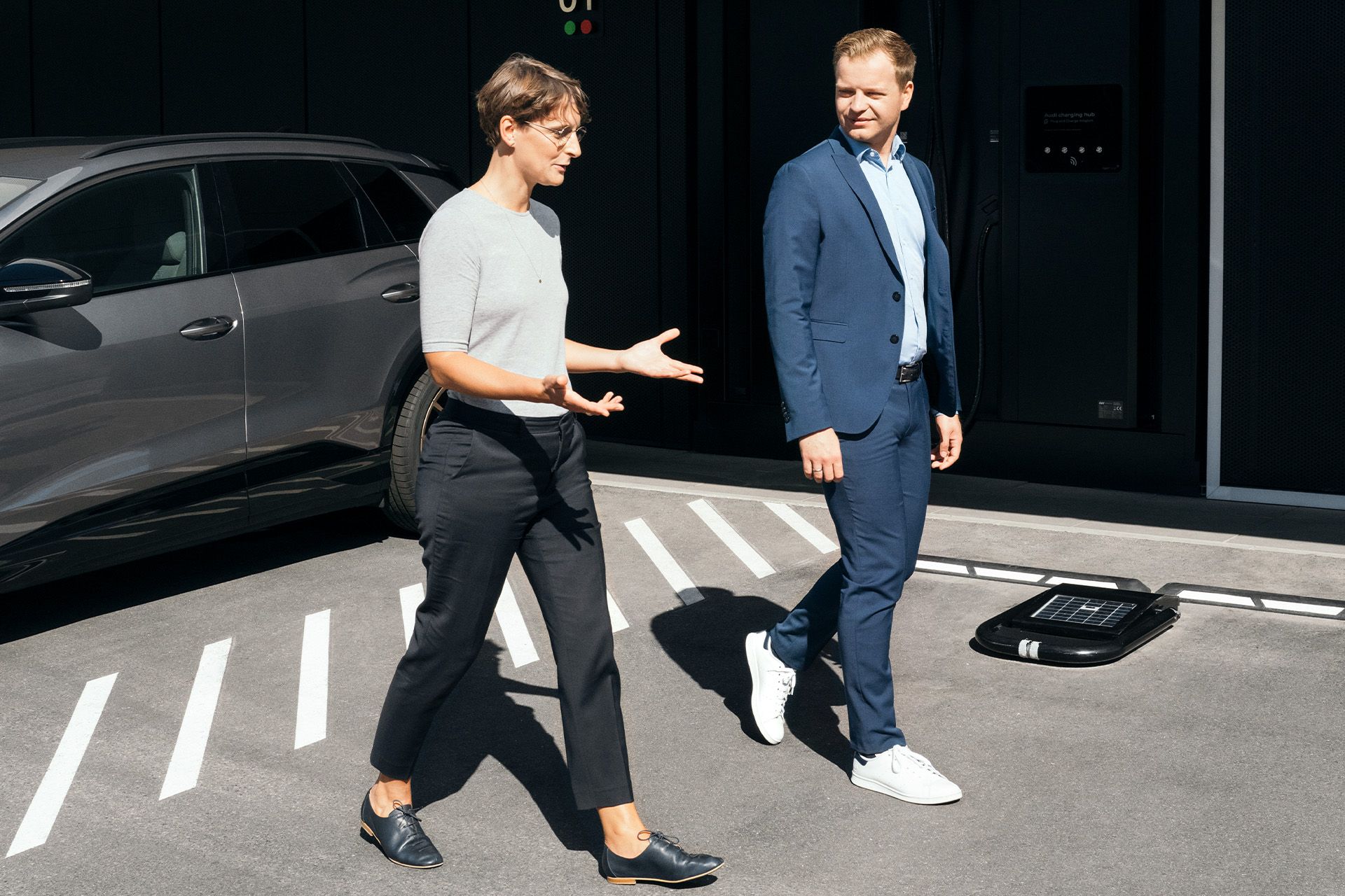 Les experts en durabilité Johanna Klewitz et Malte Vömel sur le parking de l'Audi Charging Hub à Nuremberg.