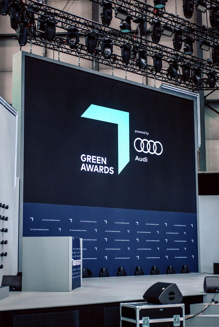 Audi ve Greentech Festival logolu bir duvar görülüyor.