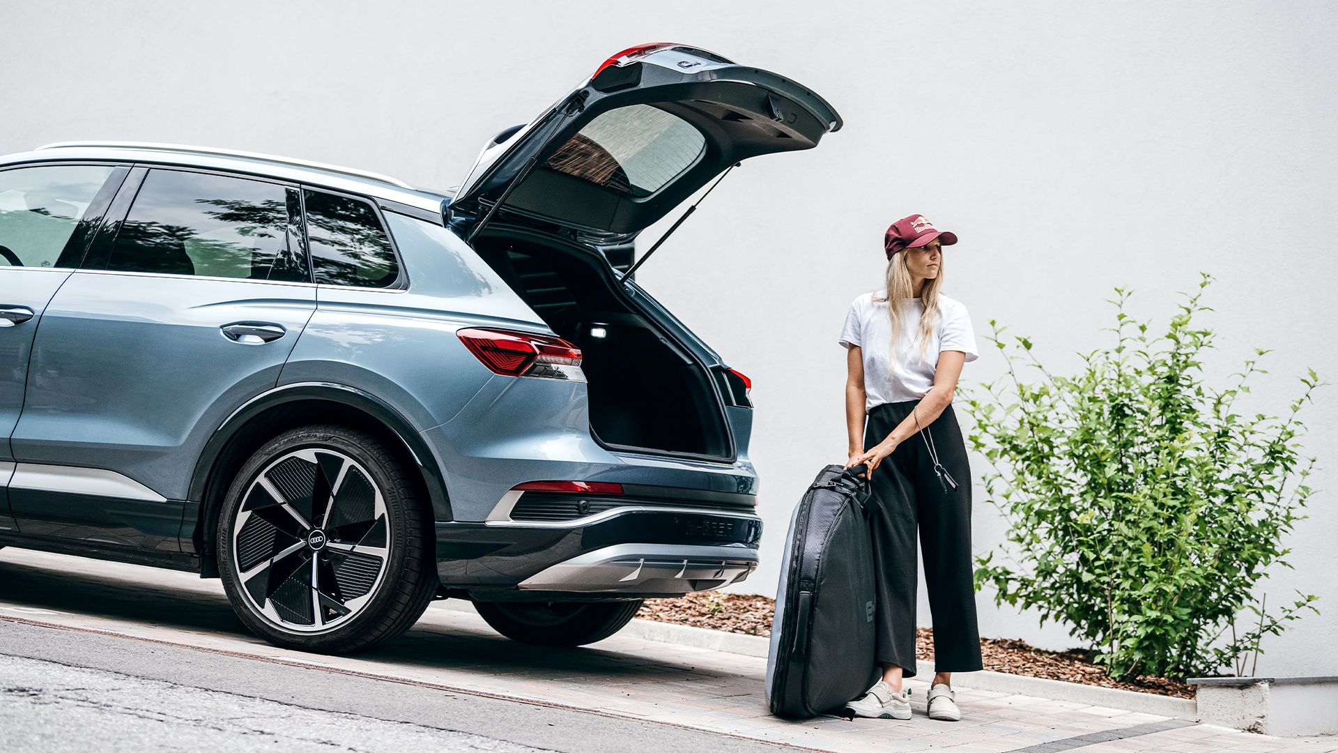 Anna Gasser si trova davanti al portabagagli aperto della sua Audi Q4 e-tron.