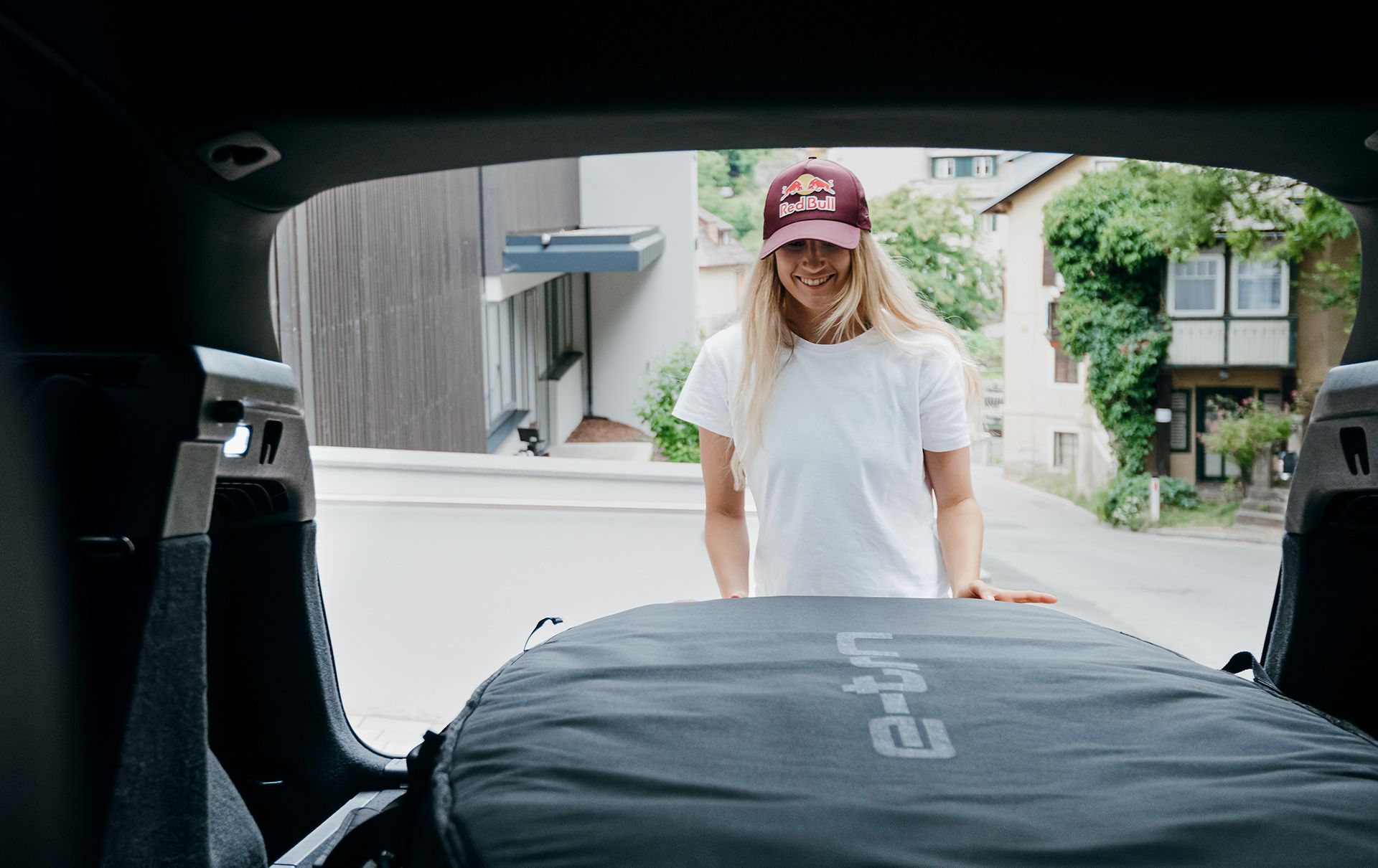 Anna Gasser carica l'equipaggiamento sportivo nel portabagagli della sua Audi Q4 e-tron.