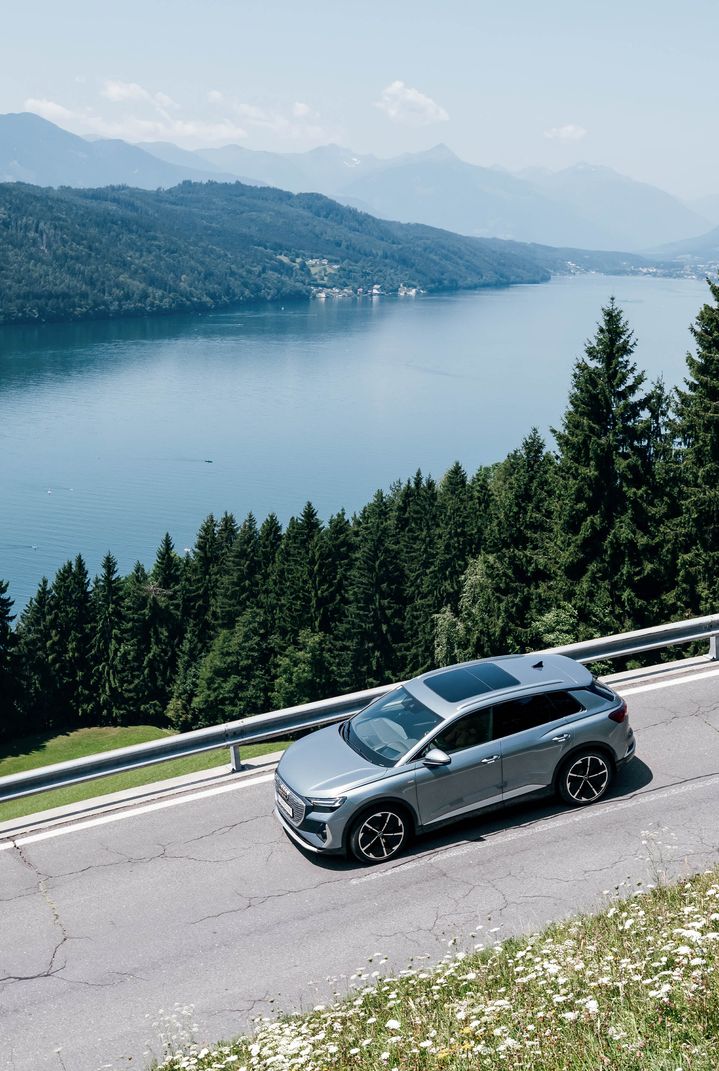 Una vista dall'alto di Audi Q4 e-tron in corsa nei pressi di un lago.