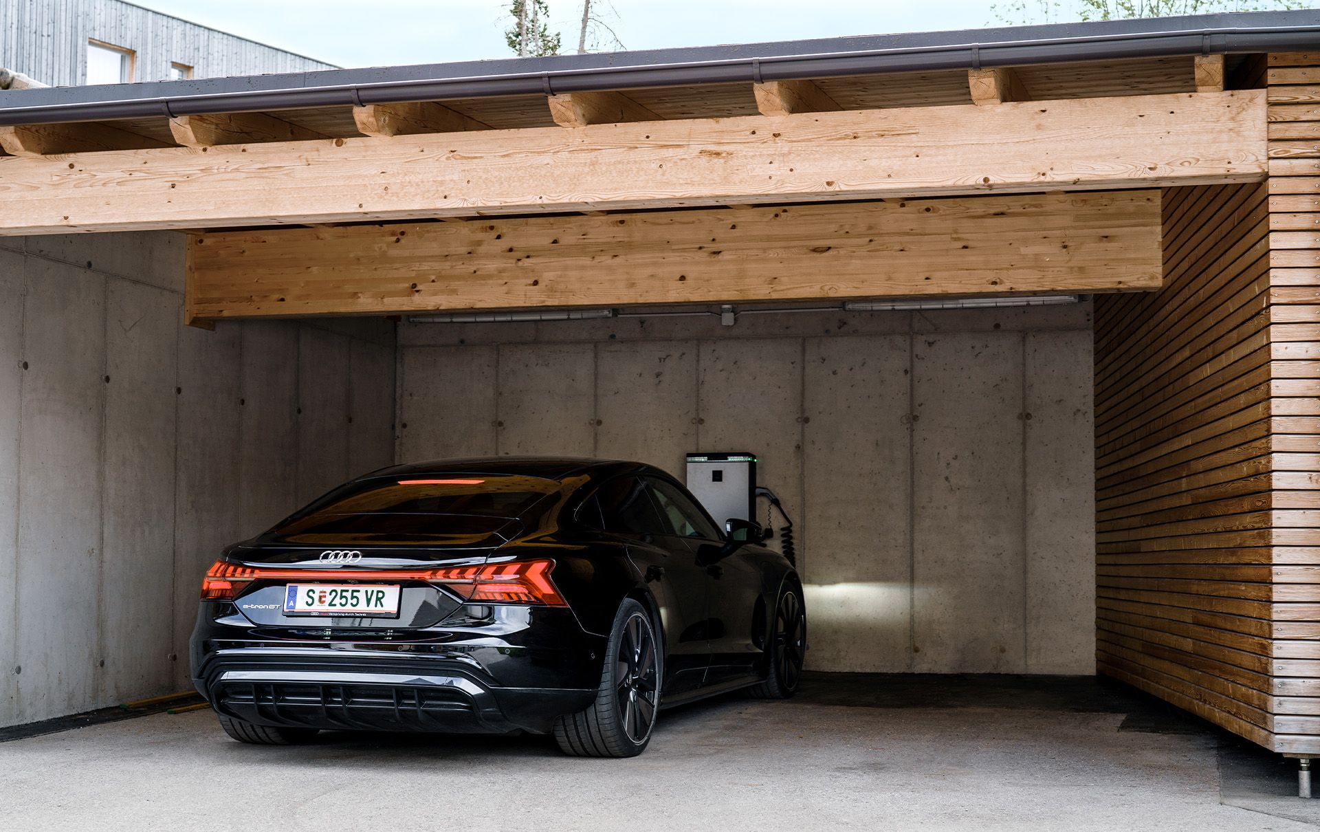 Een zwarte Audi e-tron GT quattro staat bij het laadstation van het hotel.