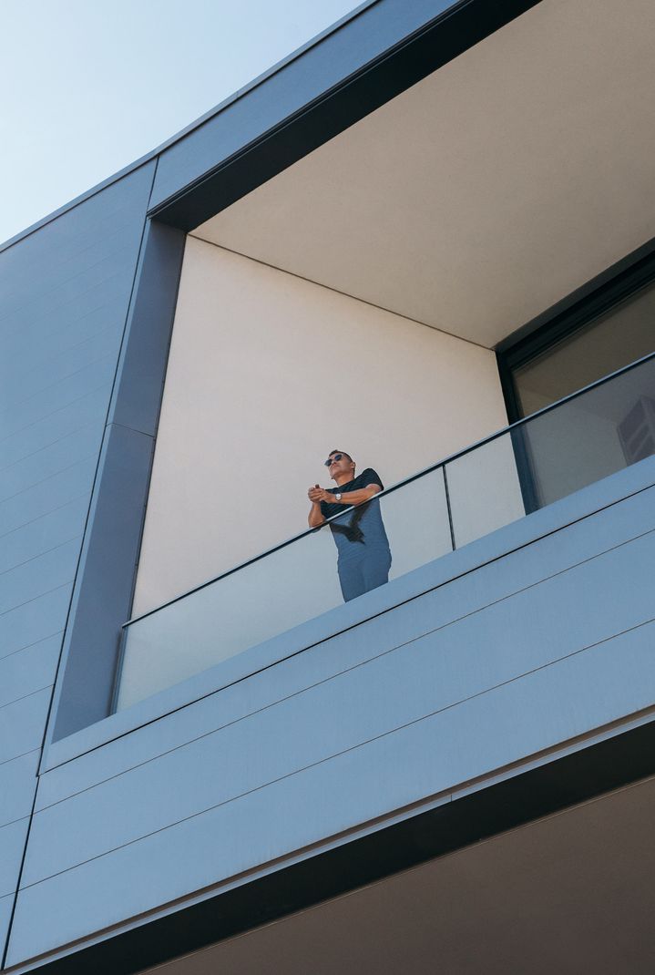 Tom Kristensen steht auf einem Balkon und blickt auf das Gelände.