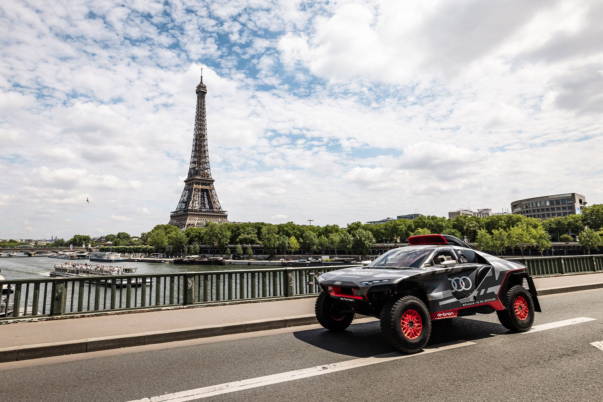Audi RS Q e-tron sur un pont à Paris avec la tour Eiffel en arrière-plan.