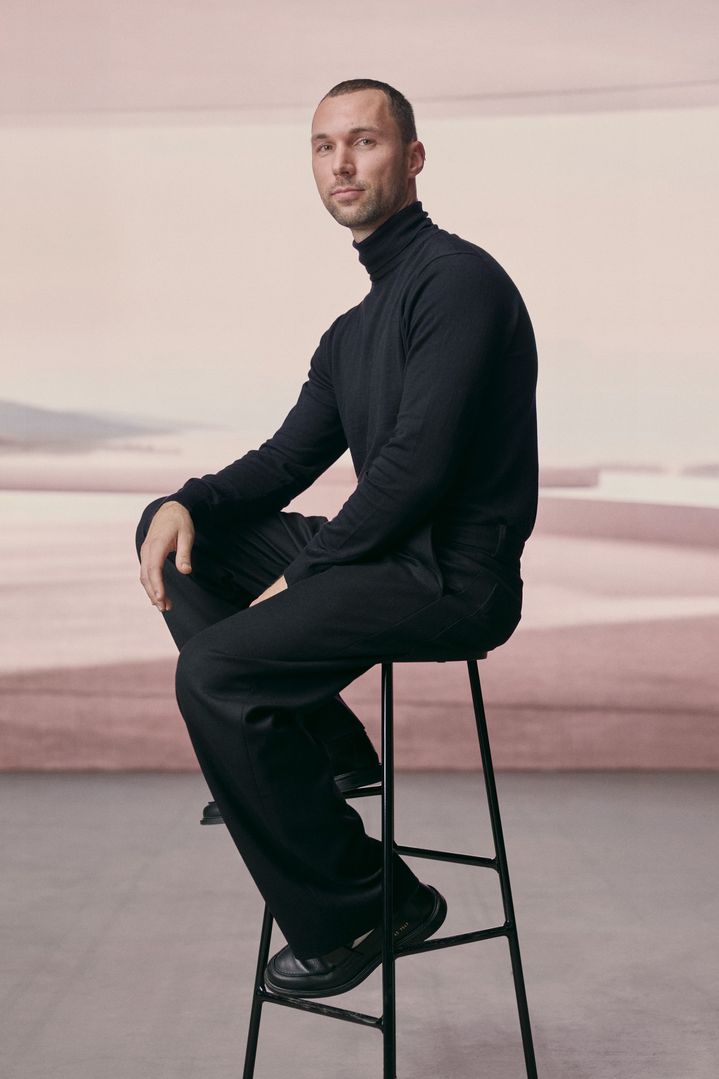 Portret van Andrés Reisinger, zittend op een barkruk.