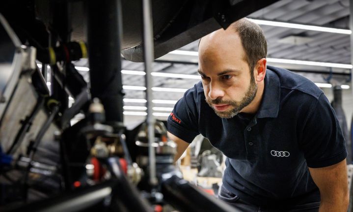 Benedikt Brunninger inspecte un détail de l'Audi RS Q e-tron démontée.