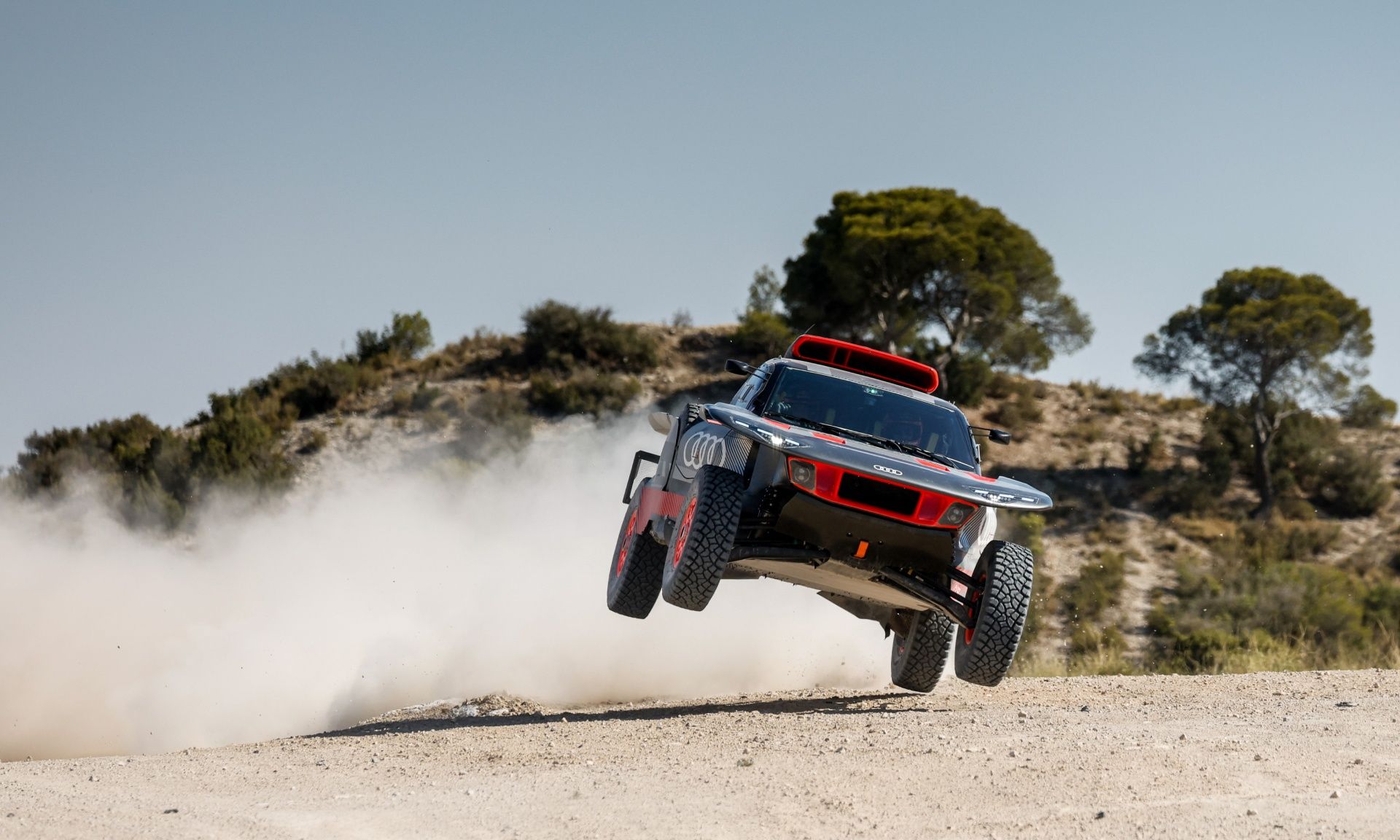 L'Audi RS Q e-tron en plein saut sur une piste gravillonnée.