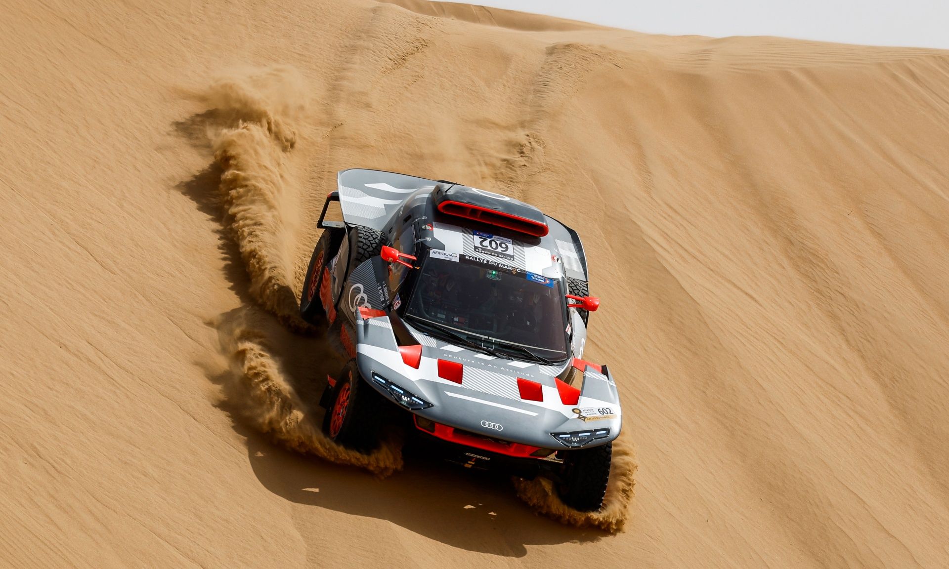 Une Audi RS Q e-tron dévale une dune.