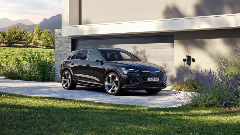 The Audi SQ8 e-tron in front of a garage.
