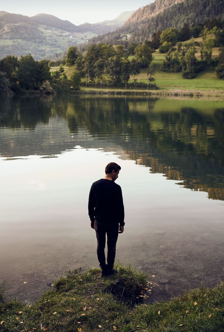 Andreas Caminada au bord d'un lac de montagne.