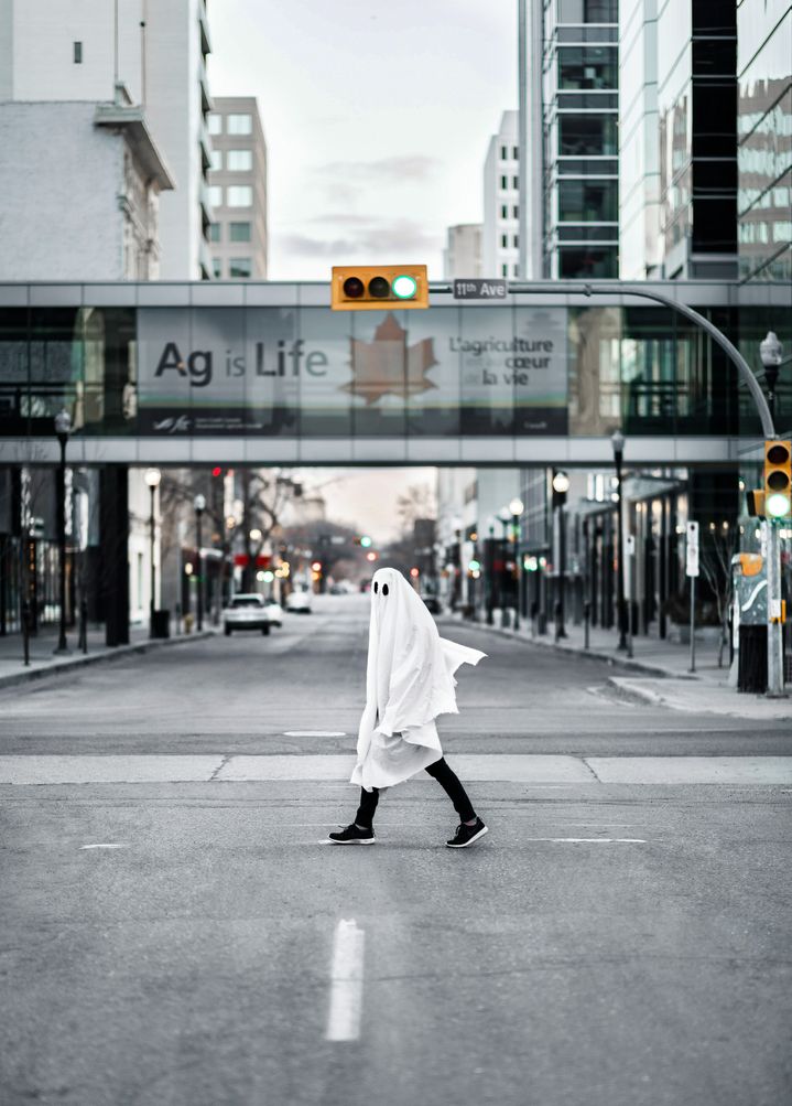 Bir hayalet gibi giyinmiş bir kişi sokakta yürüyor.