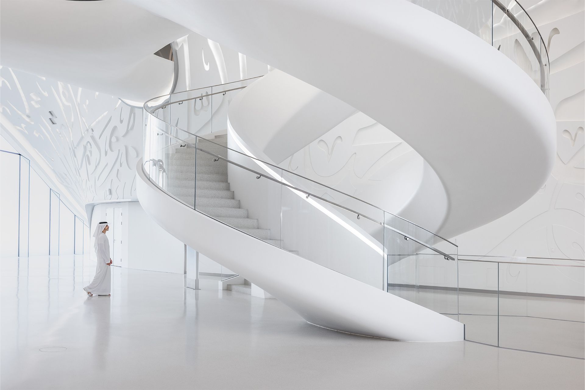 A view of the white, spiral staircase in the museum lobby.