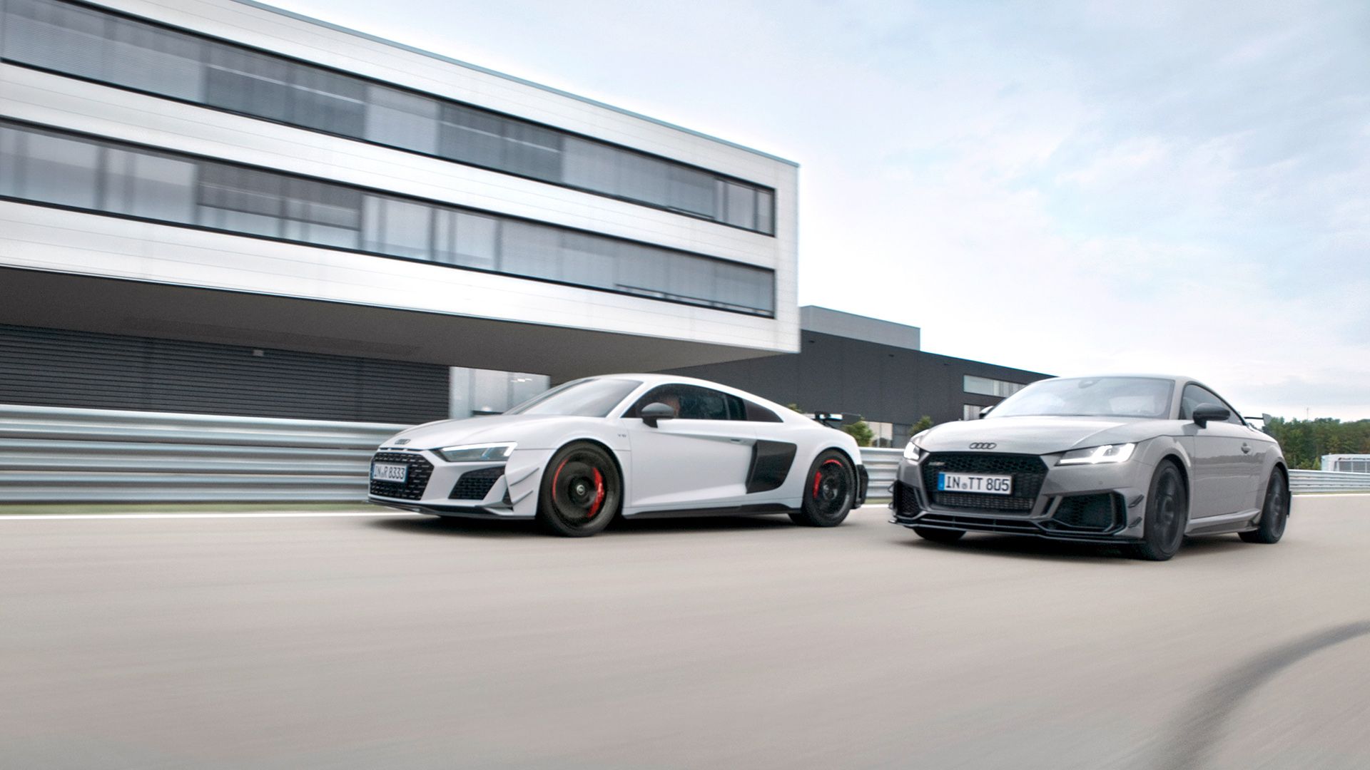 Audi R8 GT und Audi TT RS Coupé iconic edition fahren nebeneinander auf einer Rennstrecke.