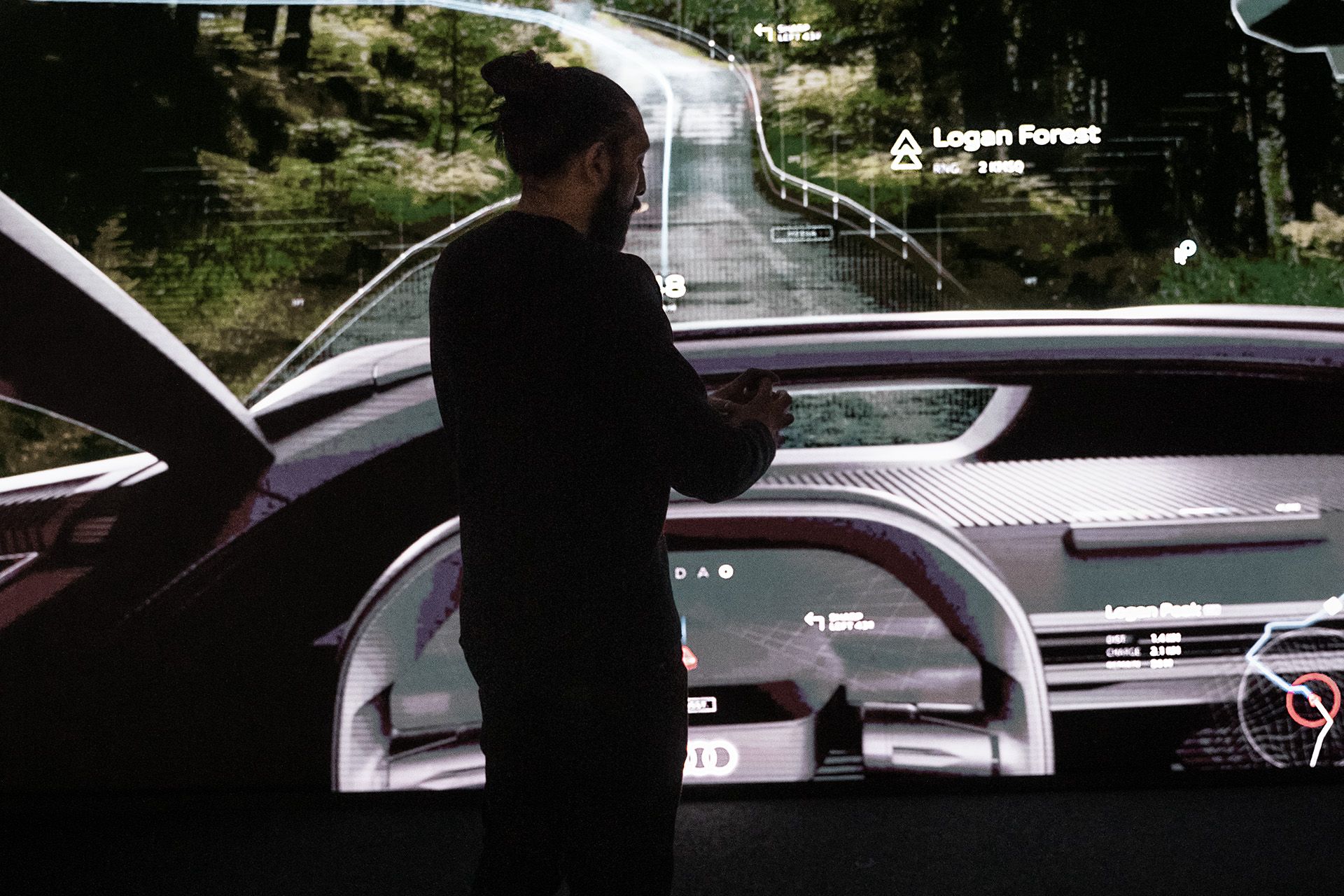 Sid Odedra 站在车辆驾驶舱投影前。