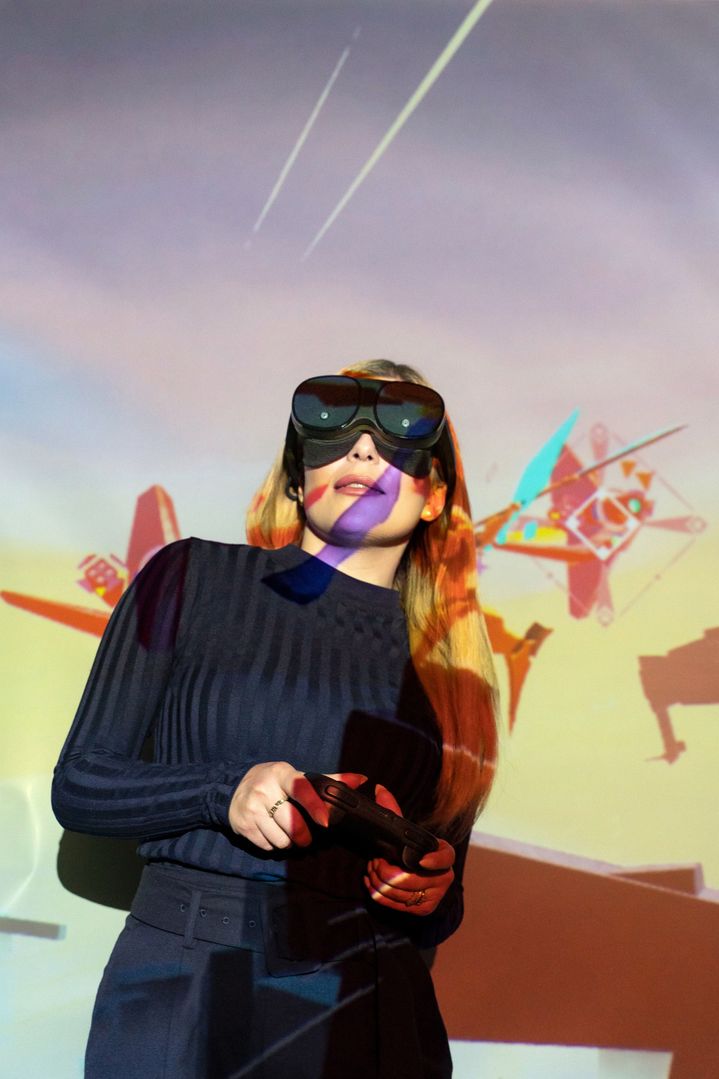 Gli occhiali VR e il controller di holoride posizionati su una superficie colorata.