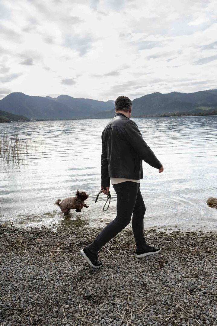 Nils Wollny spaziert mit seinem Hund am See entlang.