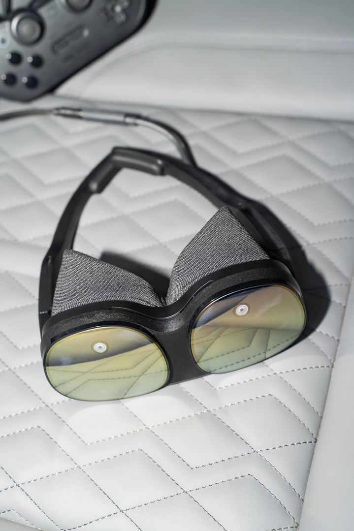Eine VR-Brille liegt auf dem Autositz.