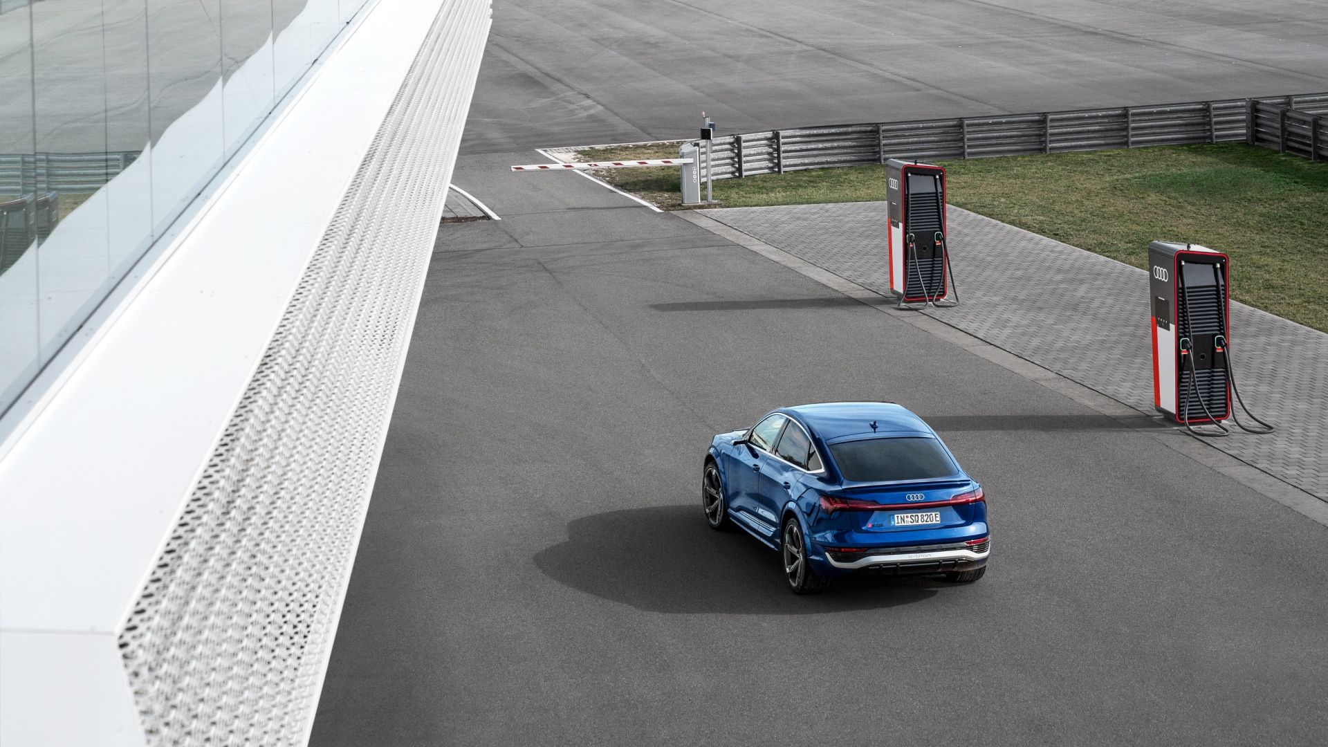 Audi SQ8 Sportback e-tron in front of several charging stations.
