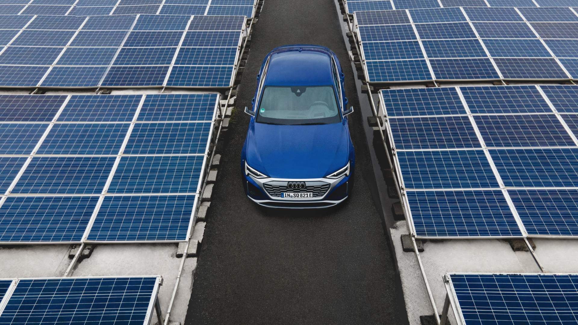 The Audi Q8 e-tron in the middle of the photovoltaic installation.