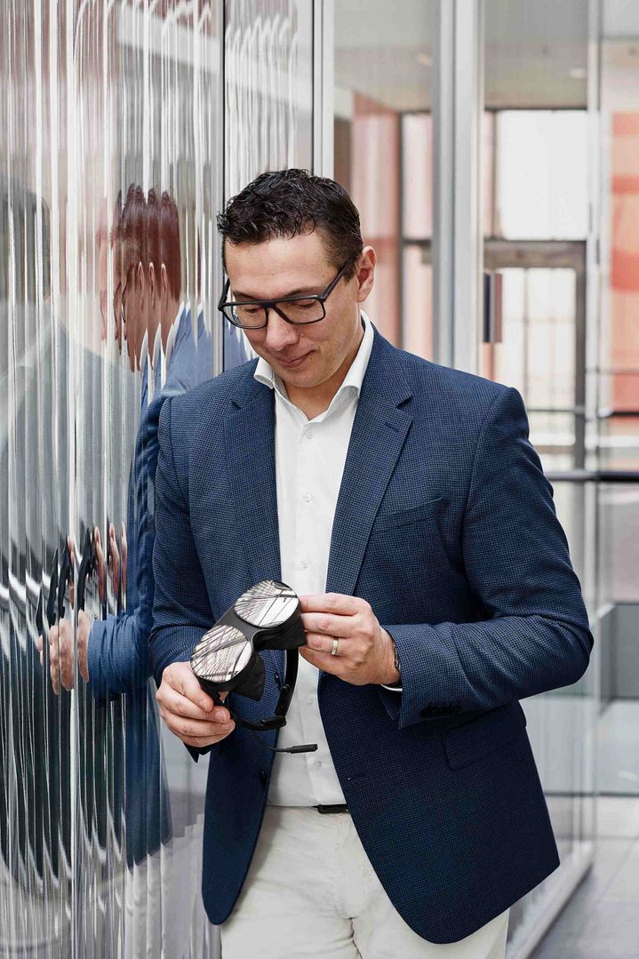 Giorgio Delucchi tenant des lunettes de réalité virtuelle entre les mains.