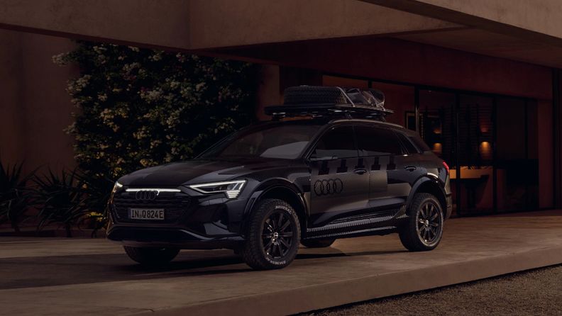 The Audi Q8 e-tron edition Dakar in front of a building. 