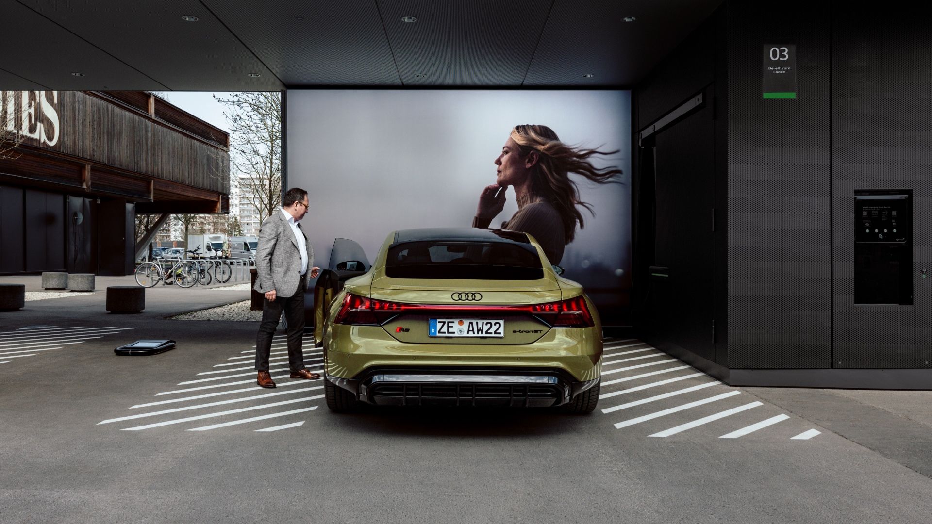 Helmuth Brants al lado de un Audi RS e-tron GT situado frente a una gran pantalla.