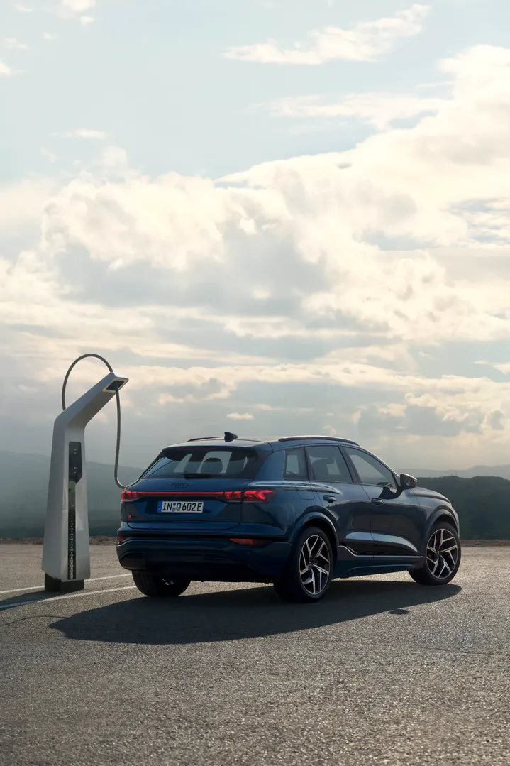 The Audi Q6-etron is pluged to a charging station.
